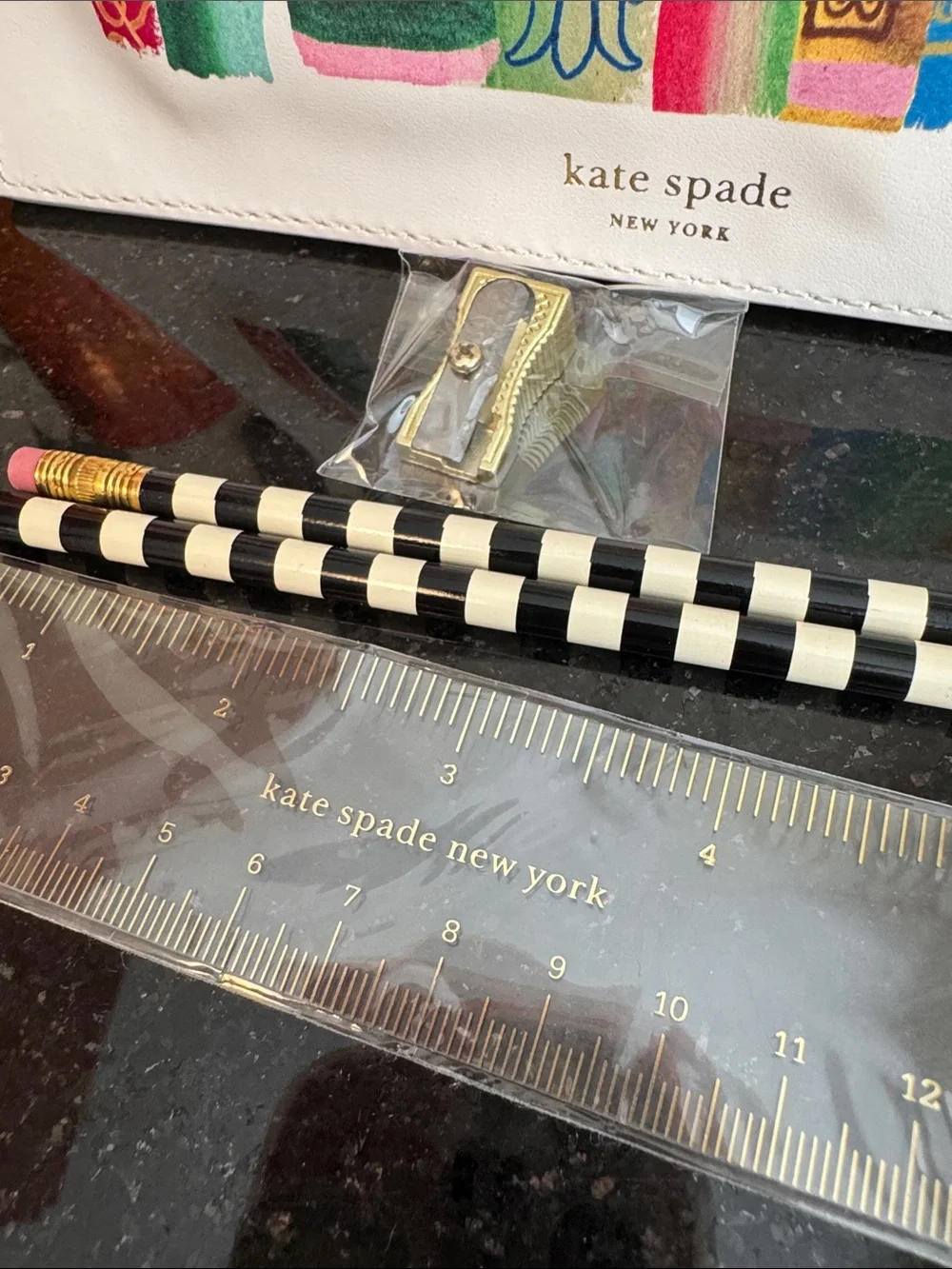 kate spade white pouch with colorful book spine print